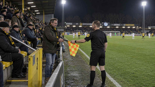 Football fan stepping out of the stands to become an assistant referee during a Belgian Cup match.