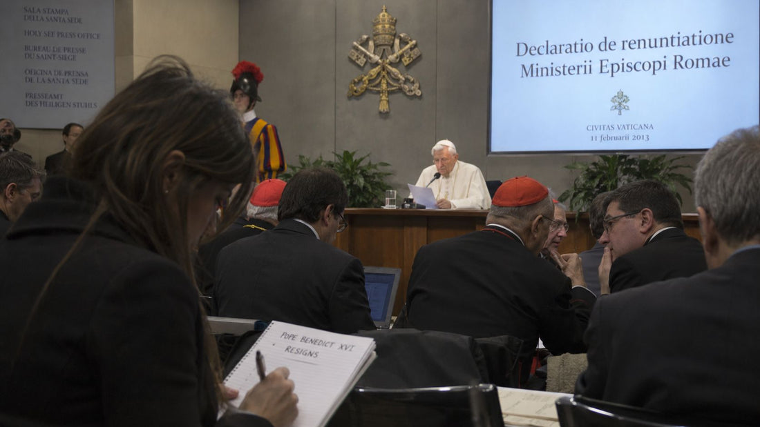 Journalist recognising the significance of Pope Benedict XVI’s Latin resignation announcement while others in the room look uncertain.